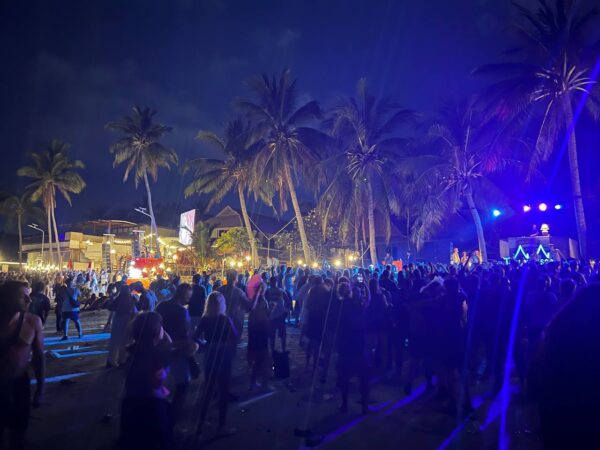 Full Moon Party on Koh Phangan at Haad Rin Beach with neon lights, beach crowd, DJs, and fire show