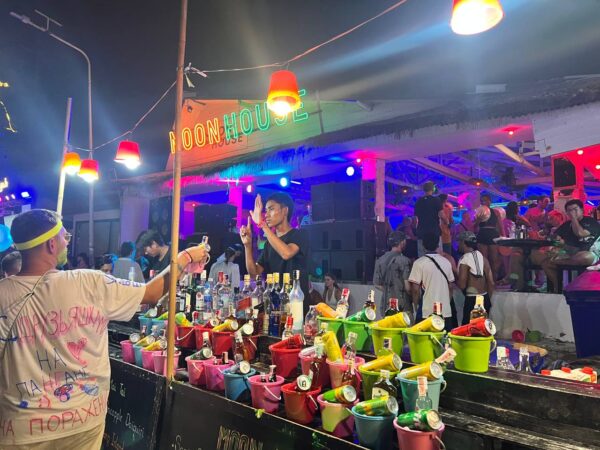 Full Moon Party on Koh Phangan at Haad Rin Beach with neon lights, beach crowd, DJs, and fire show