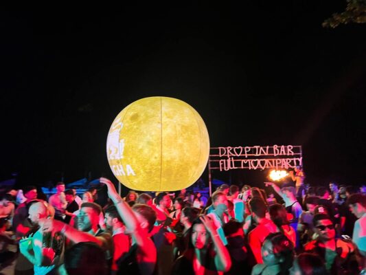 Full Moon Party on Koh Phangan at Haad Rin Beach with neon lights, beach crowd, DJs, and fire show