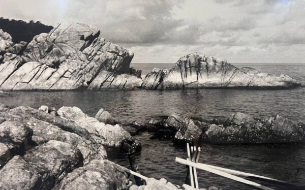 Rocky coastline and sea on Koh Phangan, Thailand, in a historical black-and-white photograph