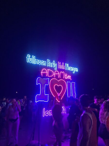 Full Moon Party on Koh Phangan at Haad Rin Beach with neon lights, beach crowd, DJs, and fire show